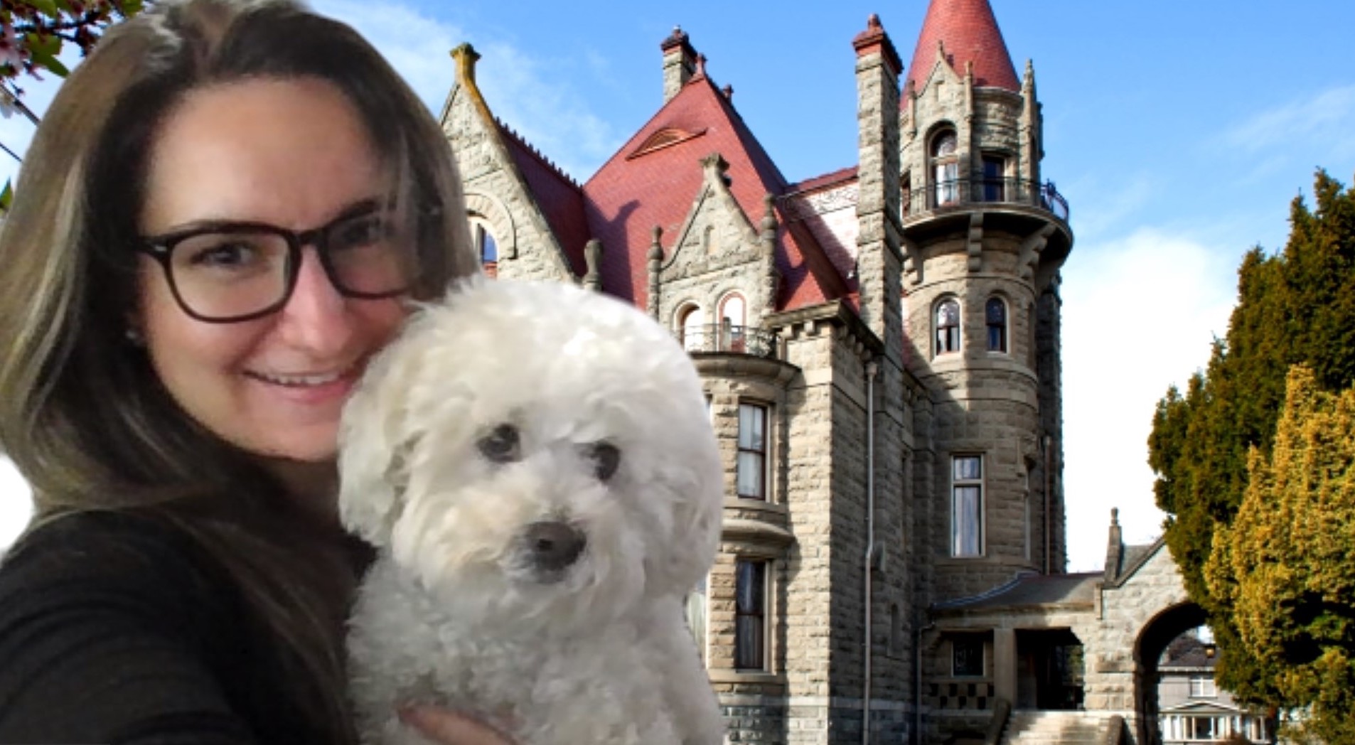 A woman poses with her dog in front of a castle.