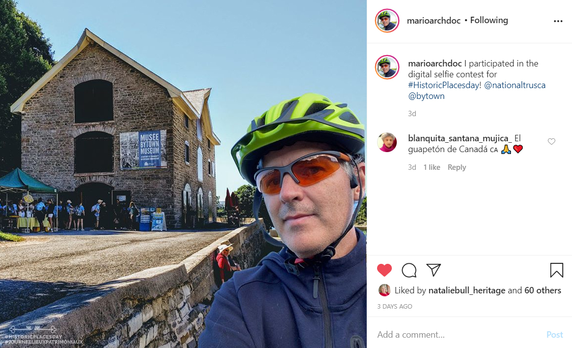 A cyclist poses in front of an old building.