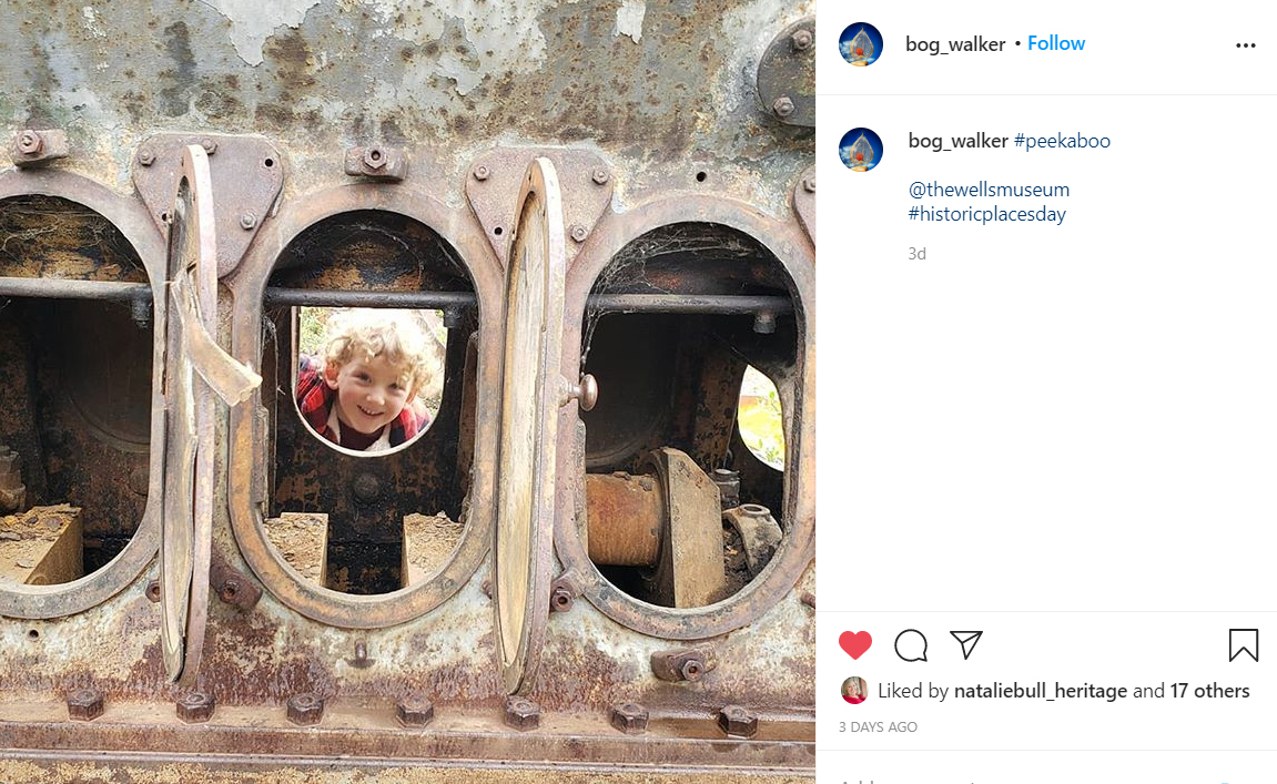 A little boy looks through a machine.